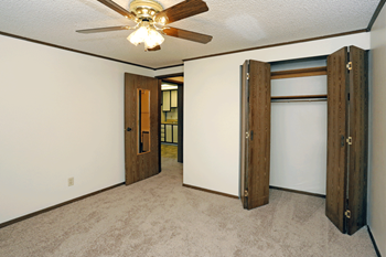 Ceiling fan in bedroom with plush carpeting.